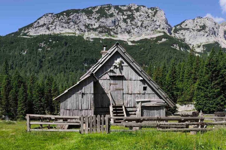 A wooden shepherd hut below mountains on Laz pasture.